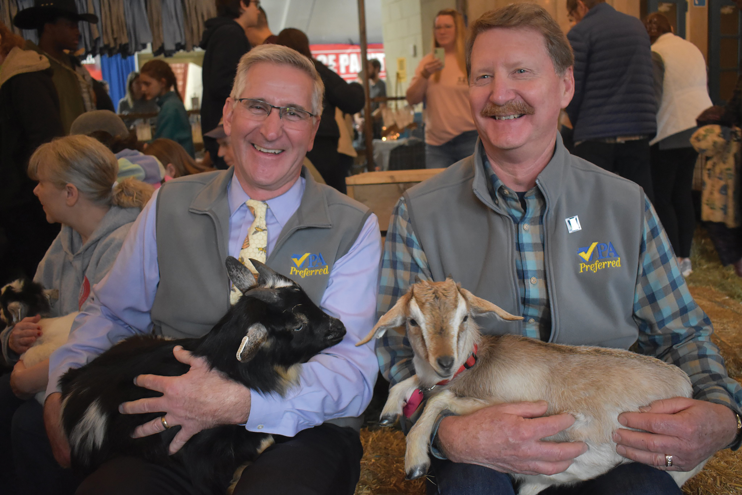 State Secretary of Agriculture Russel Redding and state Sen. Elder A. Vogel Jr. (R-Beaver) enjoy goat snuggling, a new experience at this year's Farm Show.
