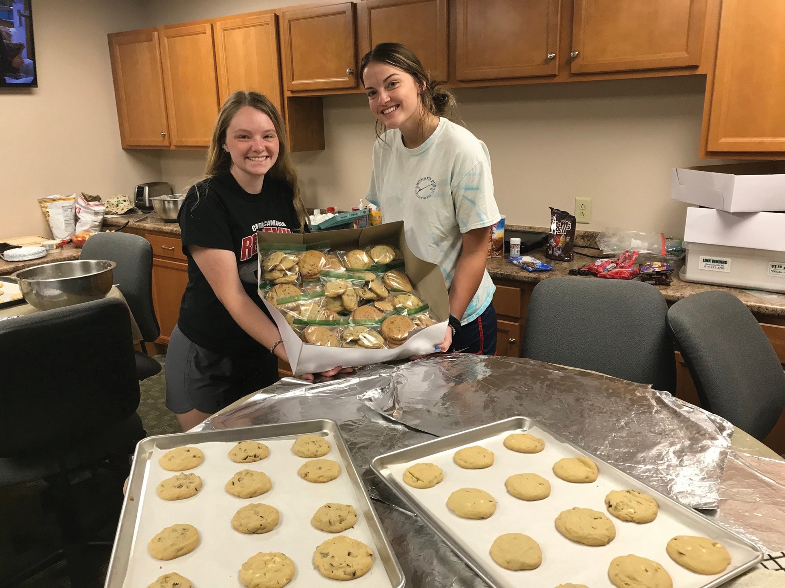 Clara Myers, left, and Jenna Bauer, summer interns at Valley REC, bake cookies in the cooperative’s kitchen to support Cookies for Caregivers, a local effort that sends sweet thank-yous to first responders and others.