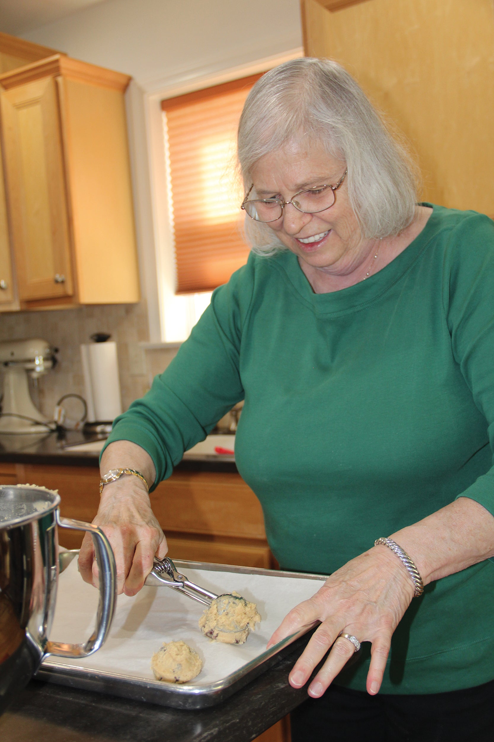 Cookie blogger Barbara Hall scoops cookie dough onto a pan for baking.