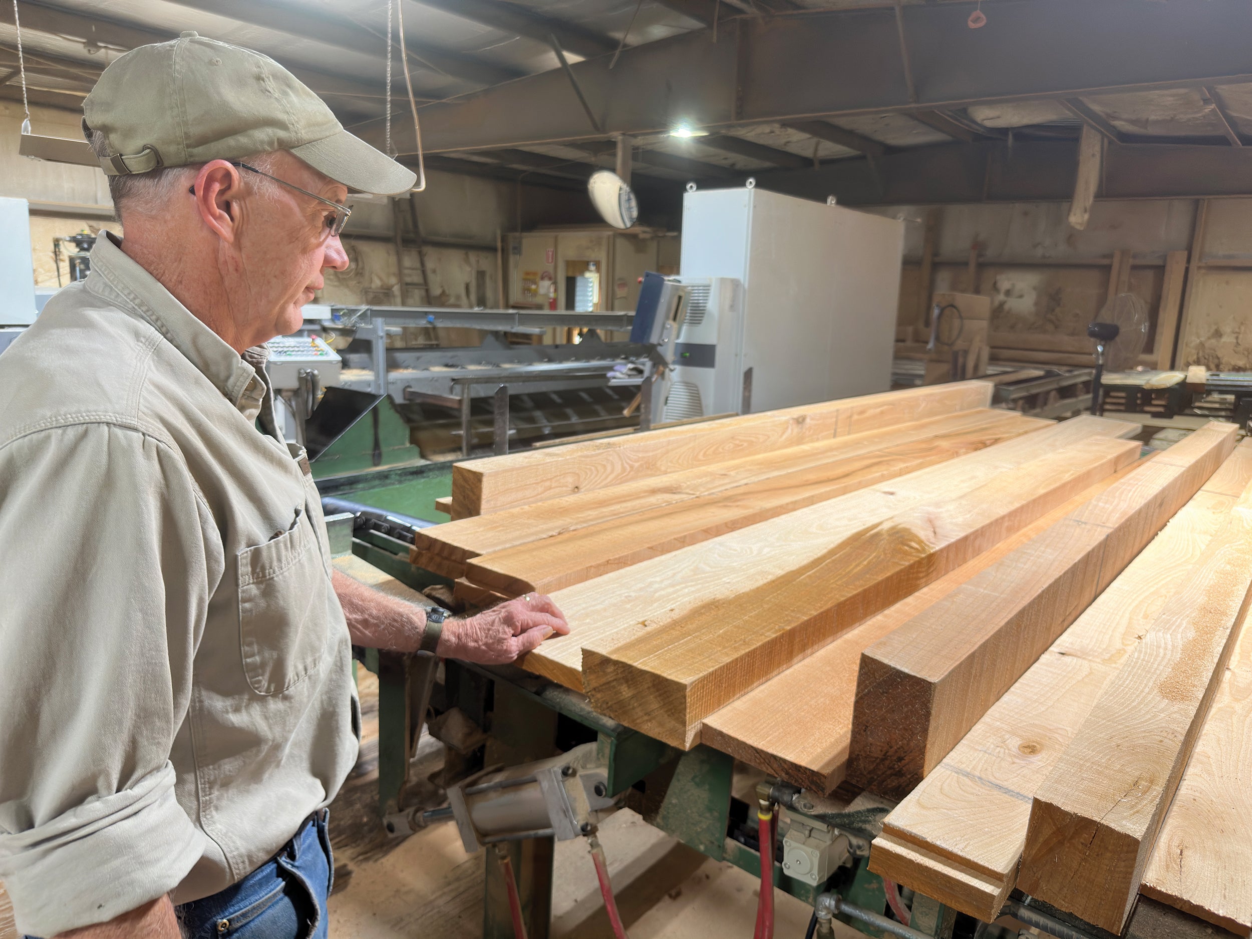 Marc Lewis, a member of Sullivan County Rural Electric Cooperative, inspects hardwood lumber milled at Dwight Lewis Lumber in Hillsgrove.