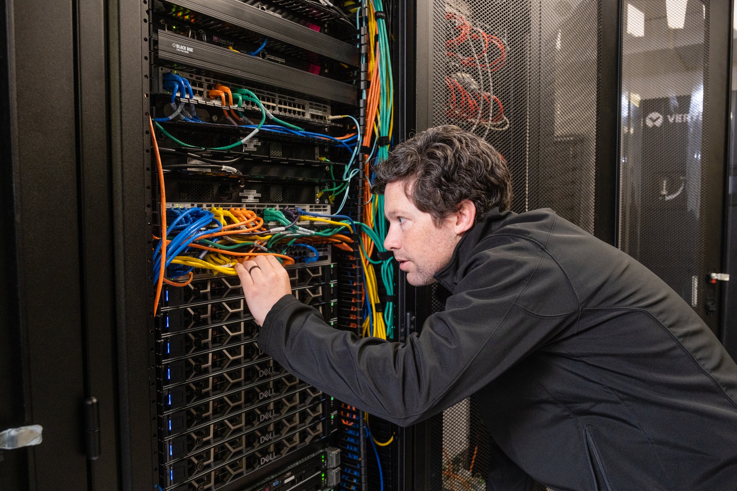 Jeremy Kelley, PREA/Allegheny Coordinated Load Management System (CLMS) operator, inspects server connections in the Harrisburg CLMS control room.