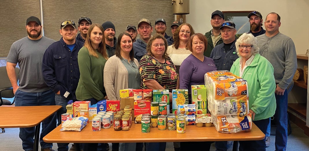Front row, from left, are employees Lindsay Fitch, Heidi Roupp, Kim Phillips and Diane White with the food pantry's Barb Davis. Back row, from left, are employees Tyler Worthen, Kevin Johnson, Shane Kline, Tom Livezey, Dave Kepner, Darrick Higley, Josh Heess, Kendall Achey, Lori Williams, Jeff Spako, Nolan Chase, Alex Laudermilch and Todd Molyneux.